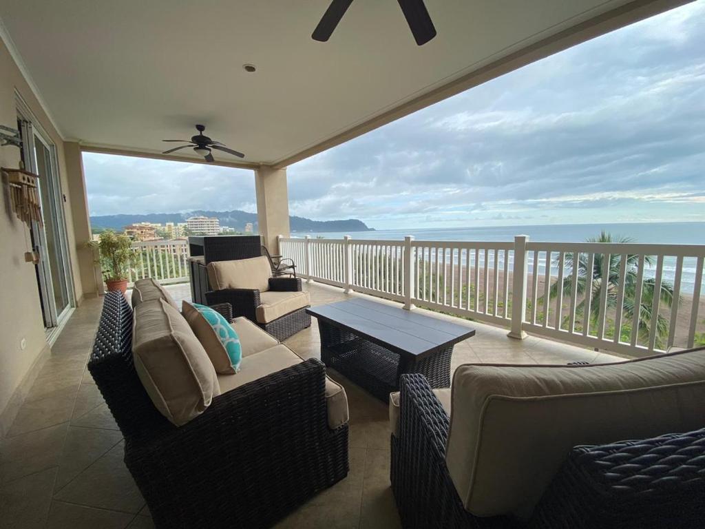 a living room with a balcony with couches and a table at The Palms Oceanfront Condo 604 in Jacó