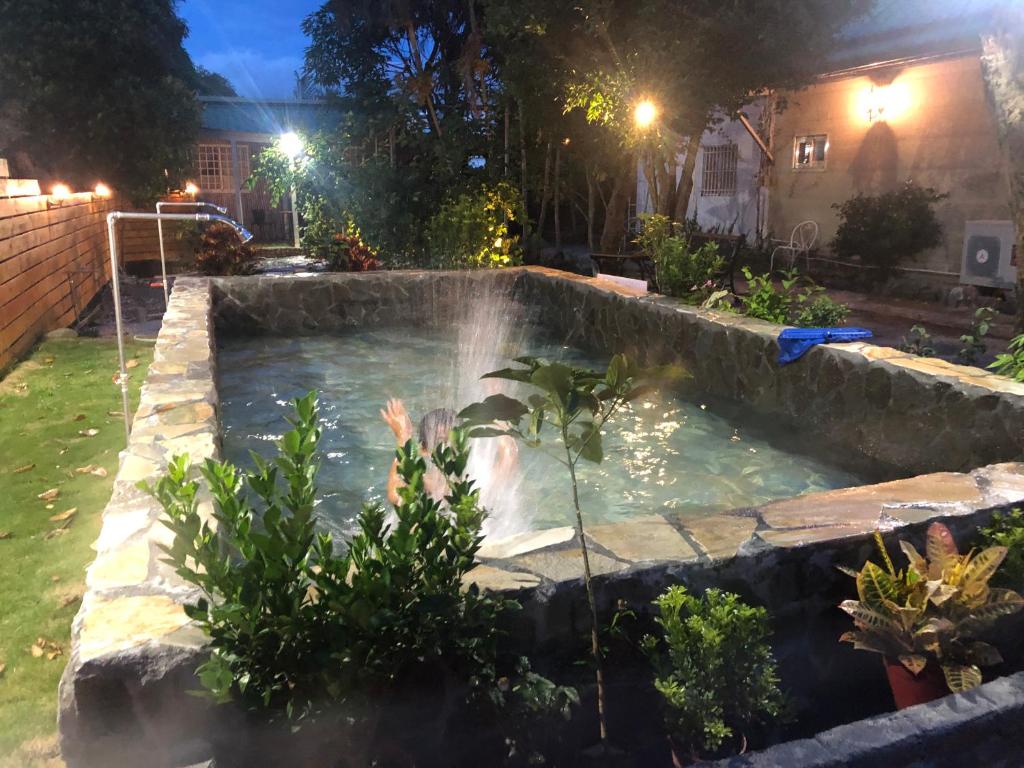 a pool with a waterfall in a yard at night at 寧靜的家14人Villa獨立設施包棟戲水池烤肉區麻將廚房私人停車場 in Hengchun South Gate