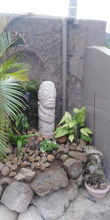 a garden with a statue in a pile of rocks at Tiki House in Bora Bora
