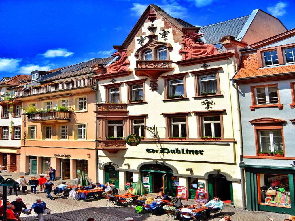un groupe de personnes assis à l'extérieur d'un bâtiment dans l'établissement The Dubliner Hotel & Irish Pub, à Heidelberg