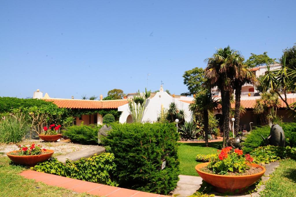 a garden with flowers and plants in front of a house at Hotel Belsole in Ischia