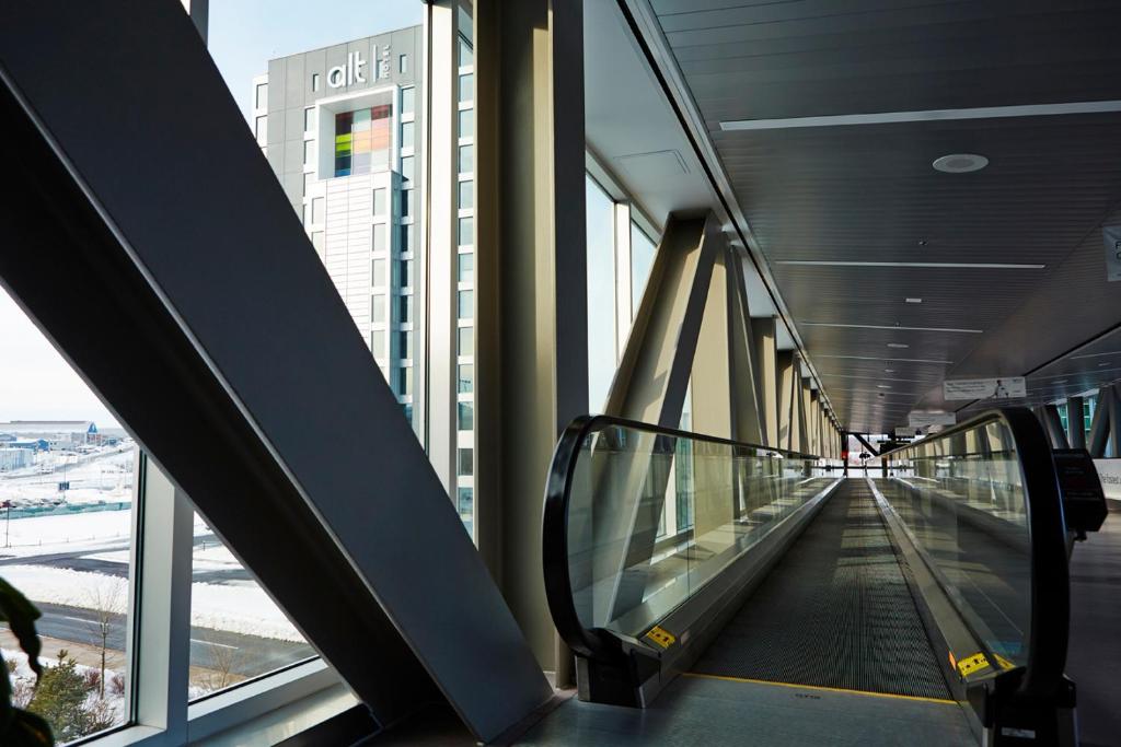 an escalator in a building with a view of a city at Alt Hotel Halifax Airport in Enfield
