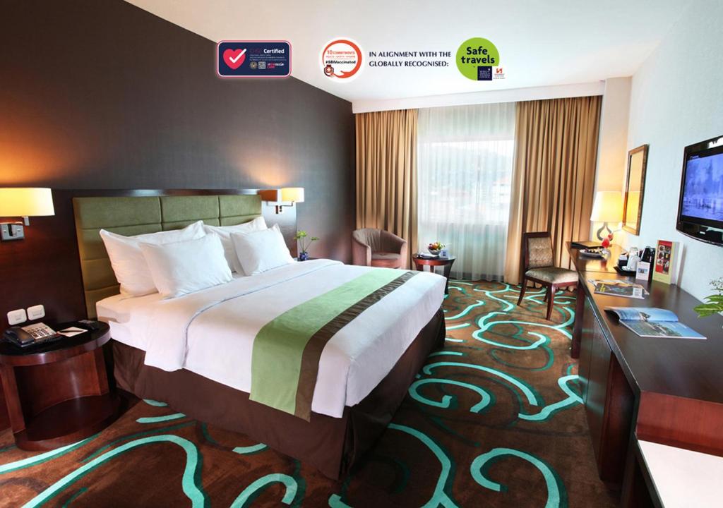 Habitación de hotel con cama grande y TV en Swiss-Belhotel Ambon en Ambon