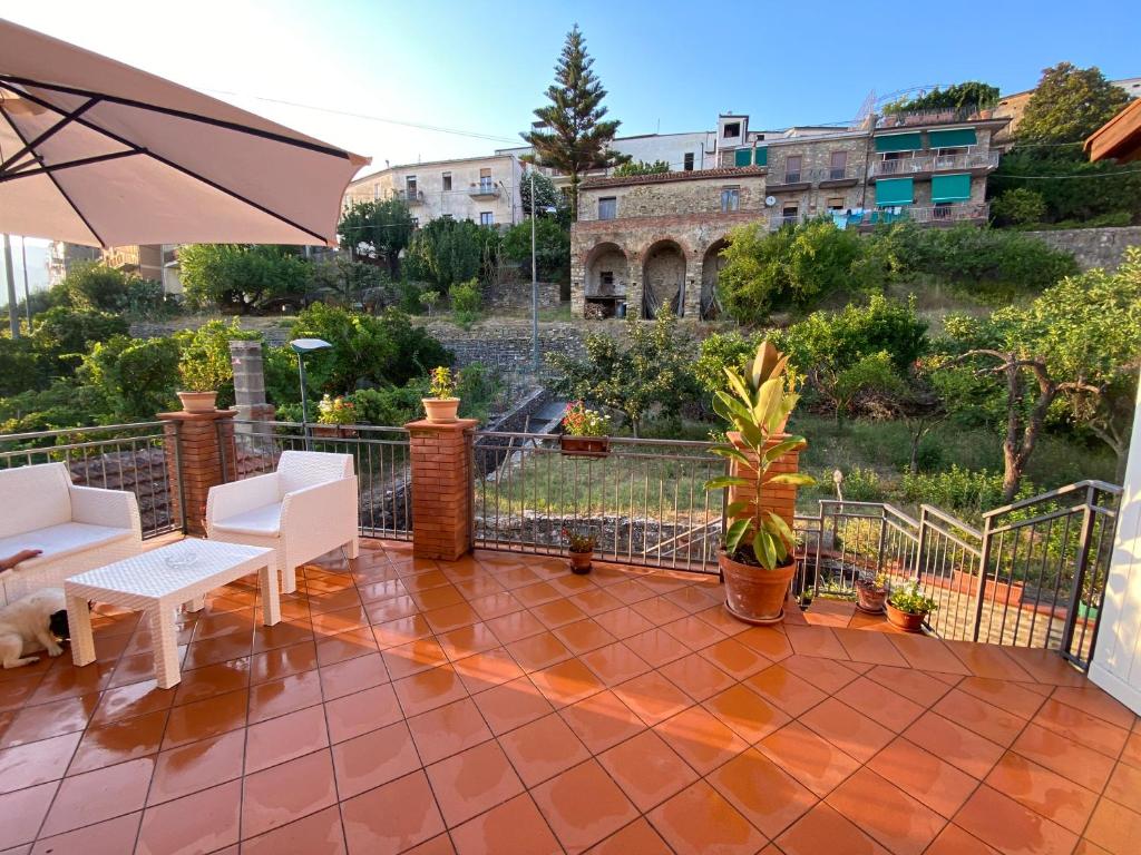 un patio con sombrilla, sillas y mesa en Villa Giordano en Acquavella