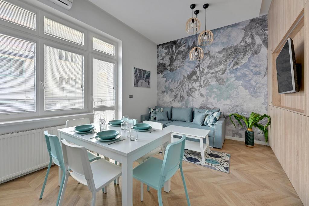 a dining room with a white table and chairs at Lion Apartments - Nicea in Sopot