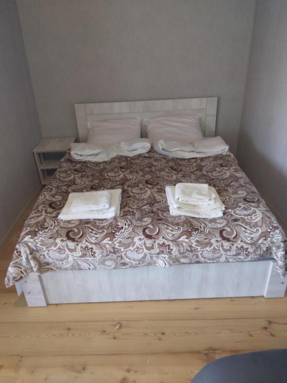 ein Bett mit zwei Bettlaken und zwei Handtüchern darauf in der Unterkunft House In The Forest in Sighnaghi