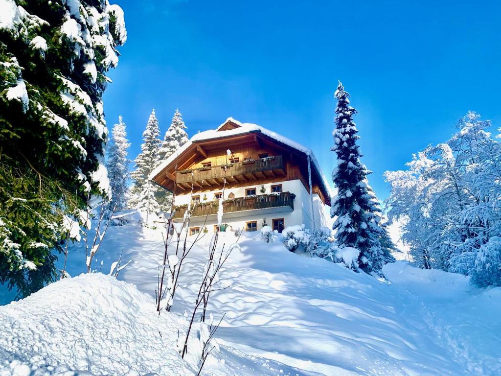 un edificio en la nieve con árboles nevados en Ferienhaus Sükar, en Bad Kleinkirchheim