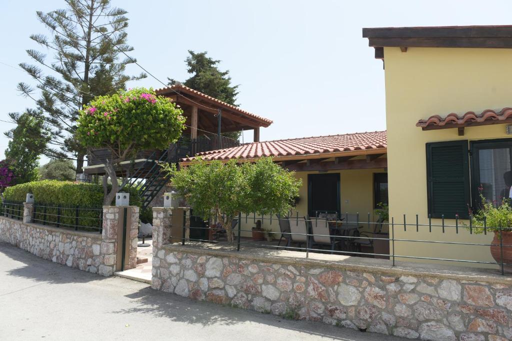 a house with a fence and a stone wall at Kiparissia villa rhodes in Phanaes
