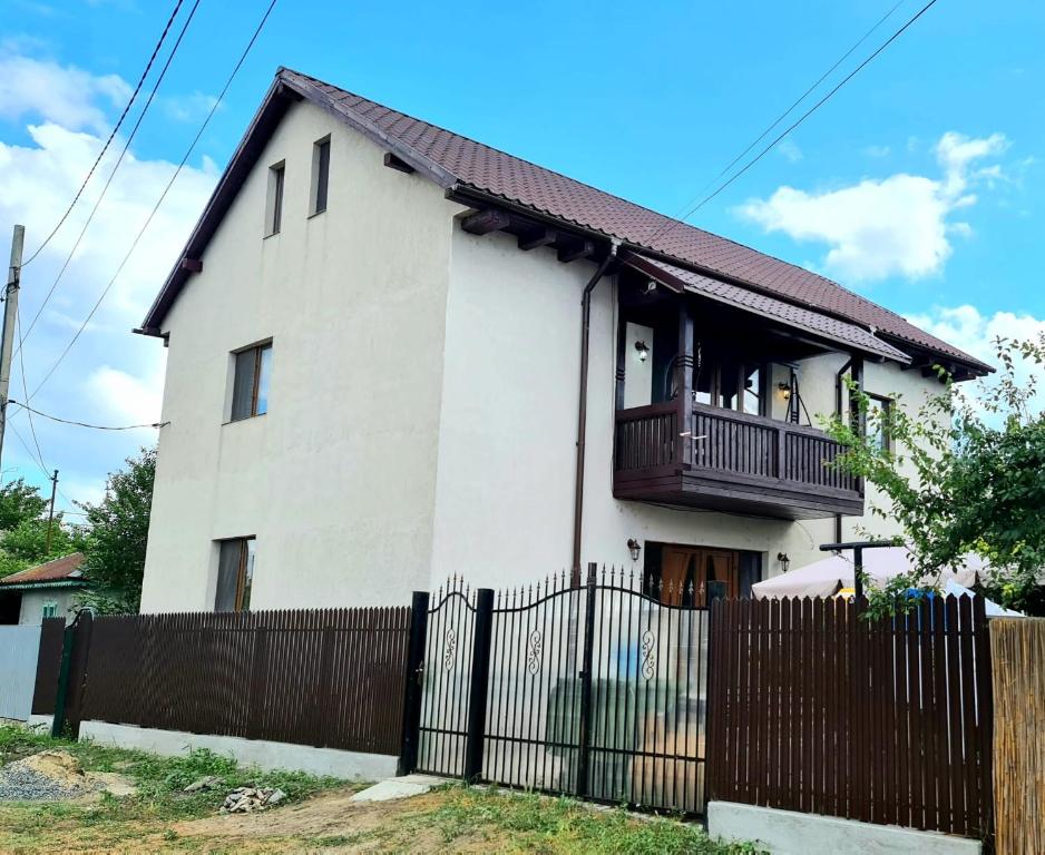 une maison blanche avec une clôture devant elle dans l'établissement Casa Arina, à Sulina