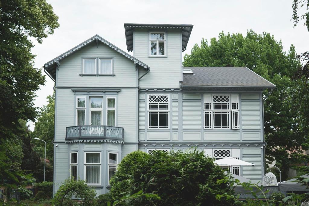 uma casa azul com um telhado preto em Roze Boutique Hotel em Liepāja