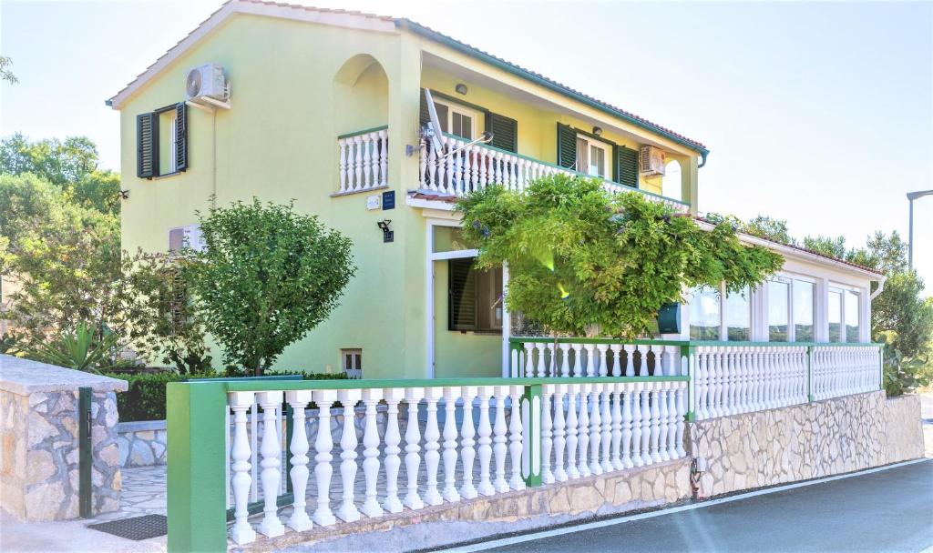 ein Haus mit einem weißen Zaun davor in der Unterkunft Apartment Pelicaric Sali Dugi otok in Sali