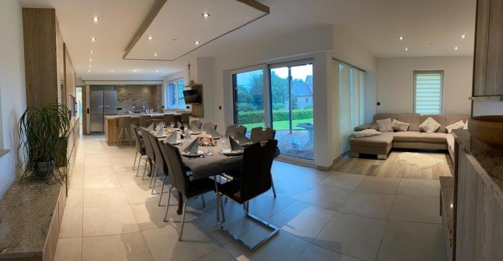 a dining room and living room with a table and chairs at Residenz Arens in Amblève