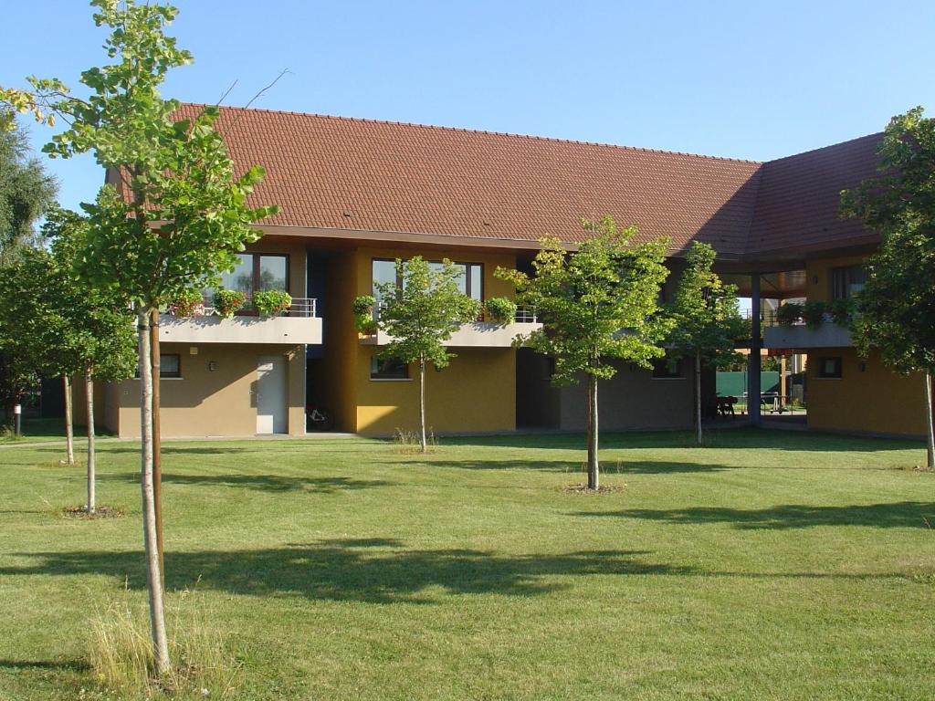 um edifício com árvores em frente em Les Loges Du Ried - Studios & Appartements proche Europapark em Marckolsheim