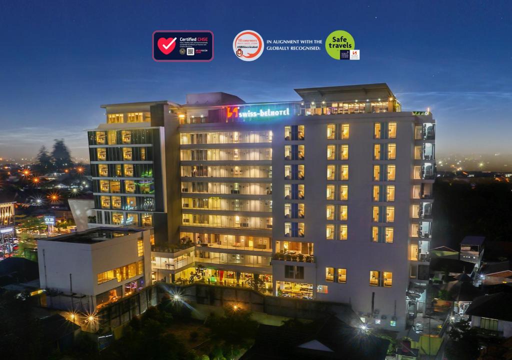 a building with lights on in a city at night at Swiss-Belhotel Jambi in Jambi