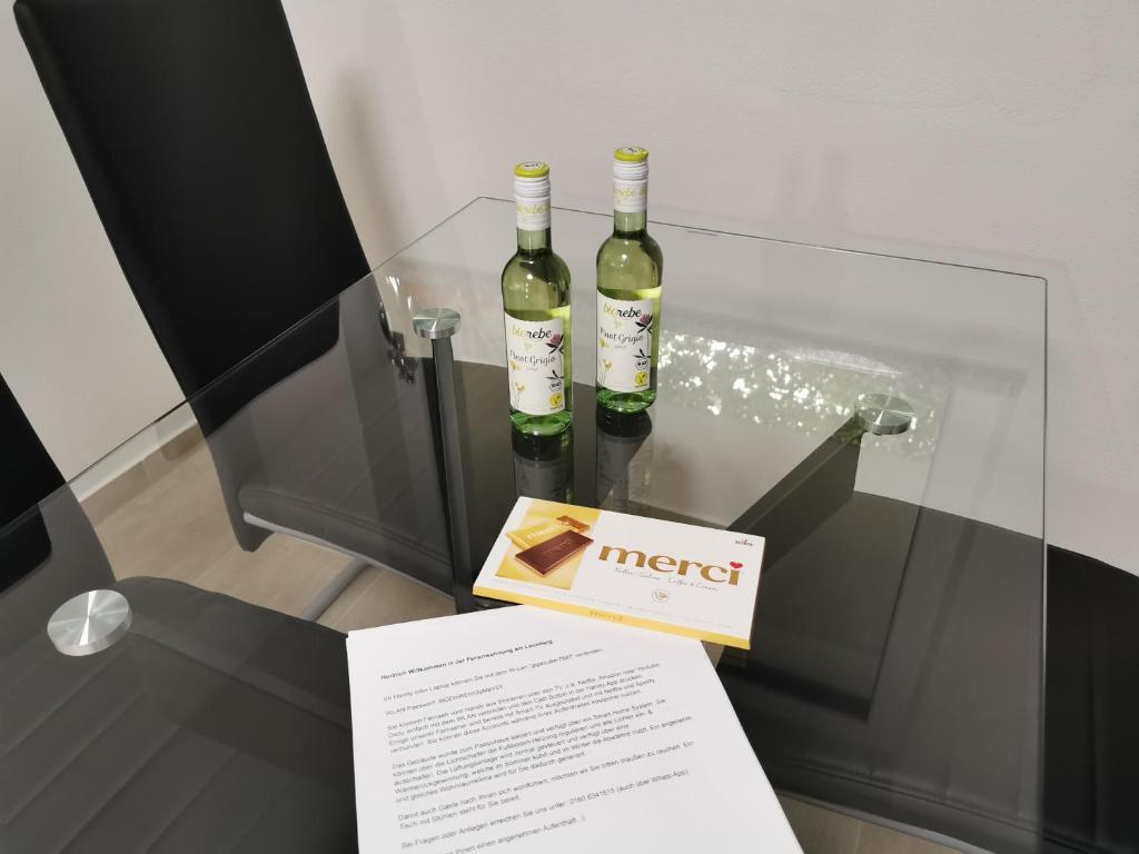 dos botellas de vino sentadas en una mesa de cristal en Ferienwohnung Annashome, en Maxhütte-Haidhof
