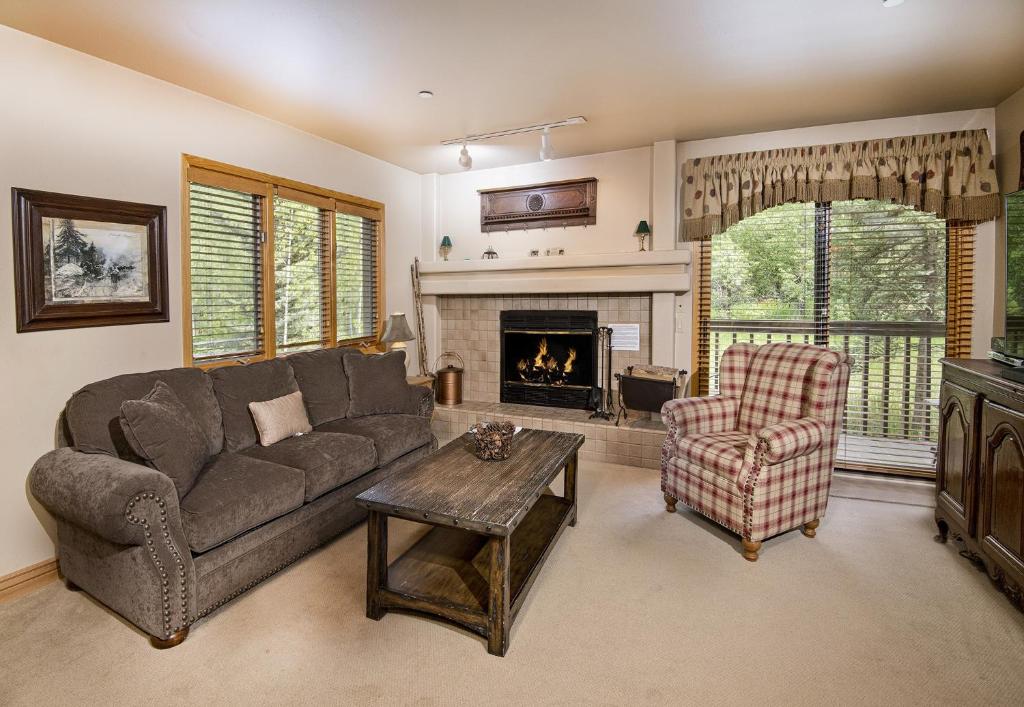 a living room with a couch and a chair and a fireplace at Townsend Place B-106 condo in Beaver Creek