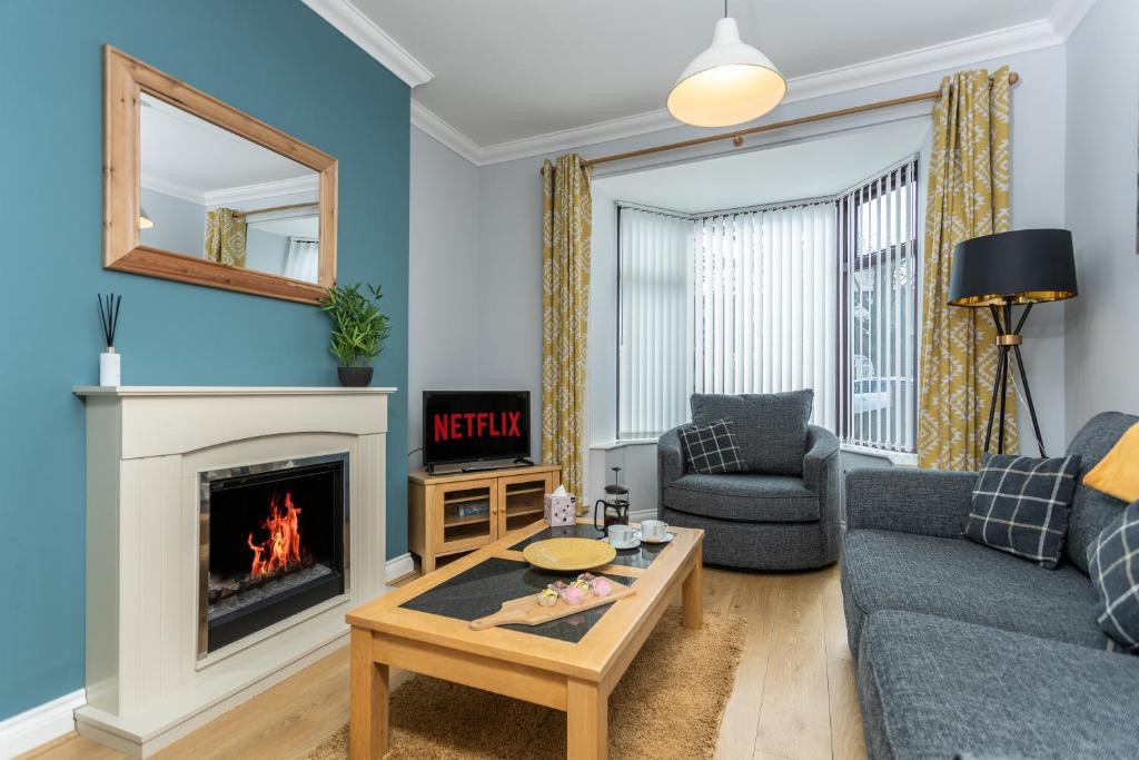 a living room with a couch and a fireplace at Merlin House in Cockfield