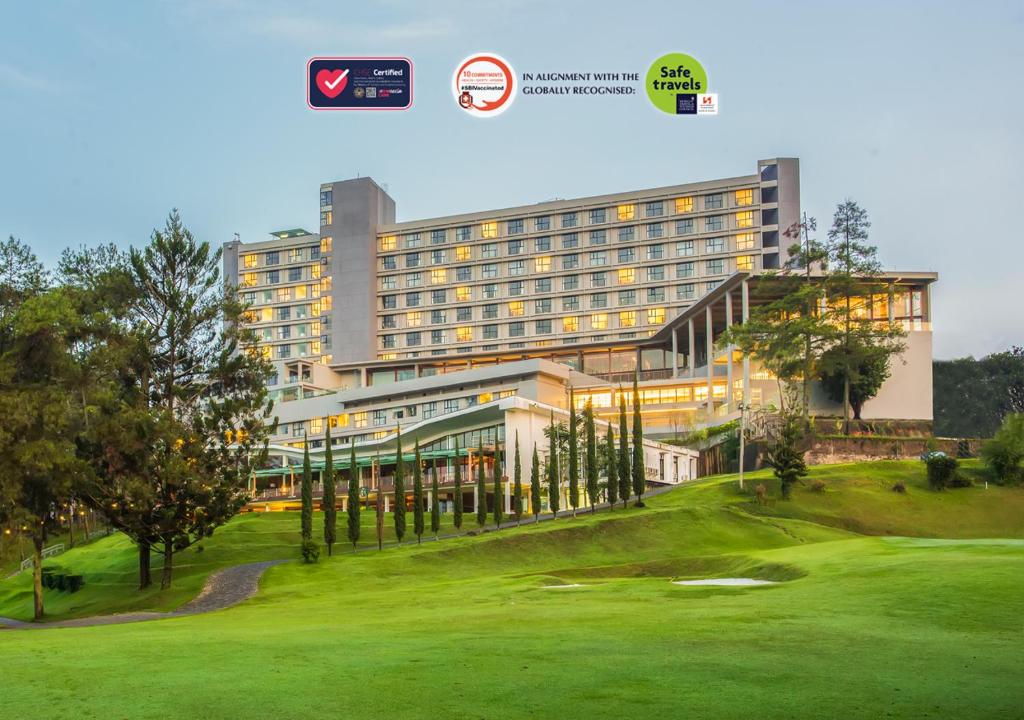 a hotel with a golf course in front of a building at Swiss-Belresort Dago Heritage in Bandung