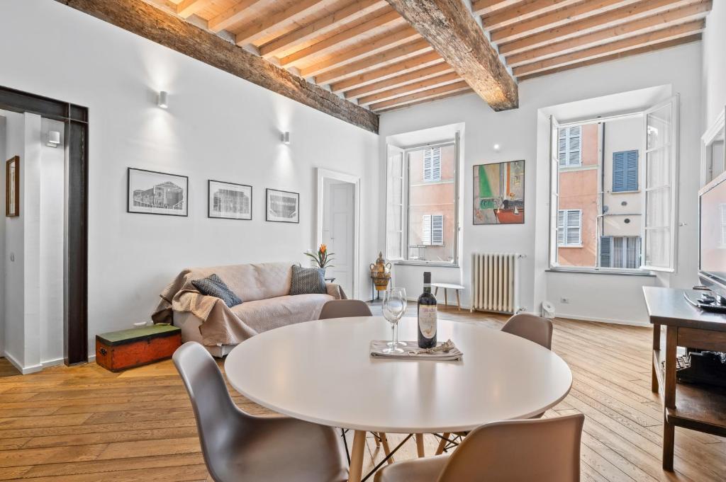 una sala de estar con una mesa y sillas en Palazzo della Pilotta Roomy and Quiet Flat, en Parma
