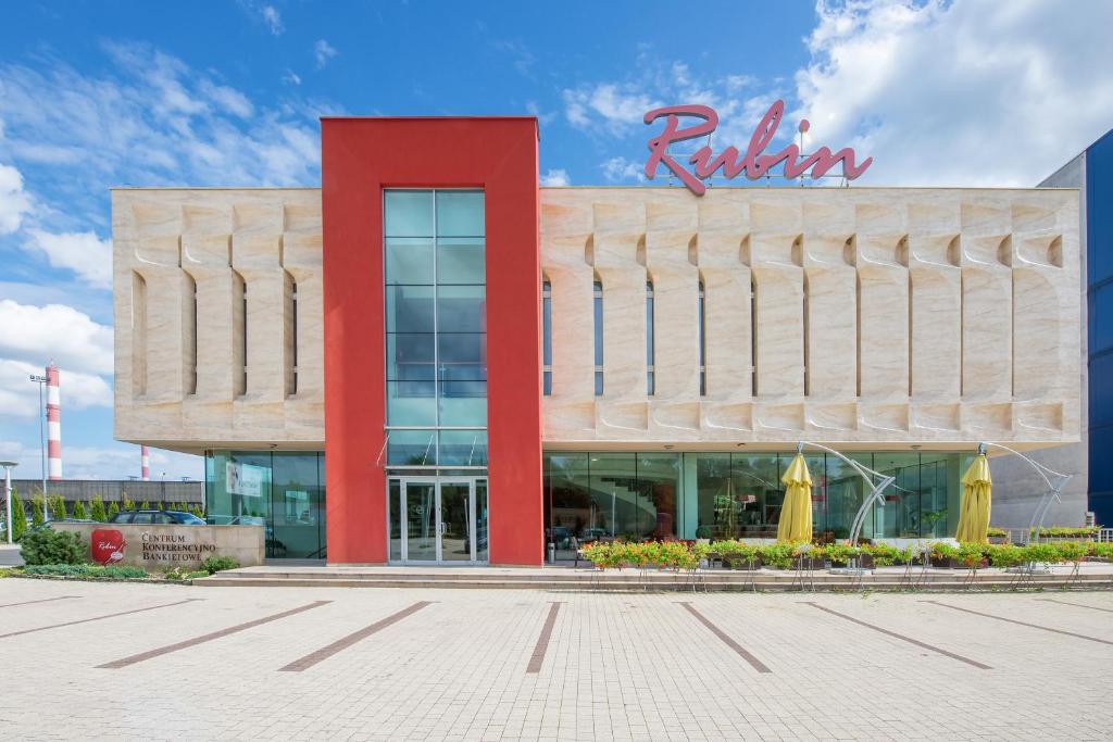 un edificio con una señal roja en la parte delantera. en Hotel Rubin, en Łódź