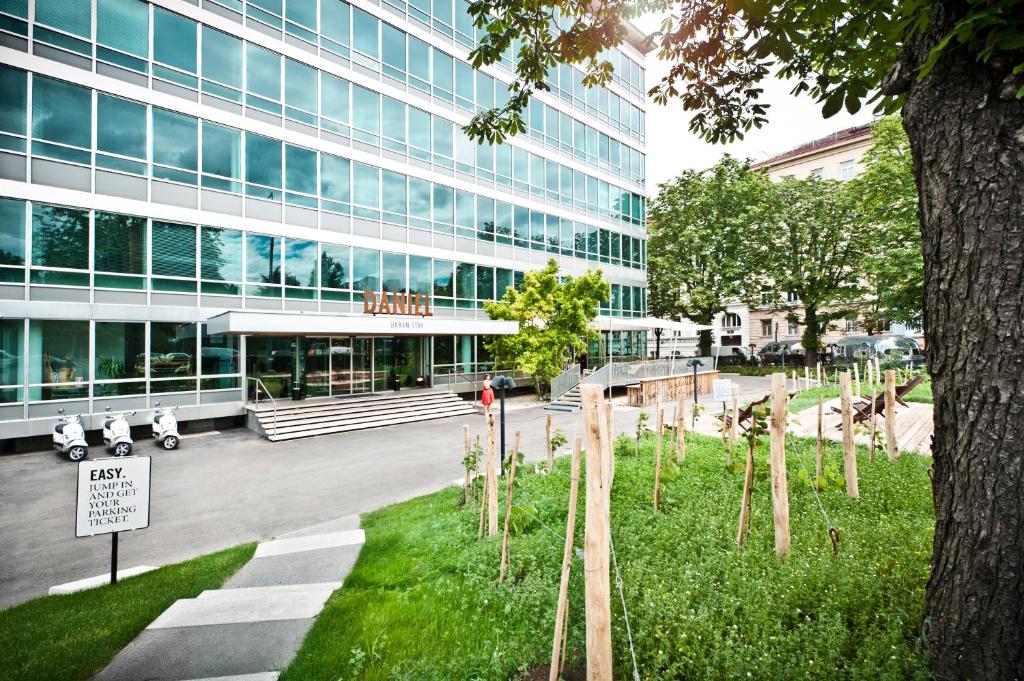 budynek z drzewem przed nim w obiekcie Hotel Daniel Vienna - Smart Luxury Near City Centre w Wiedniu
