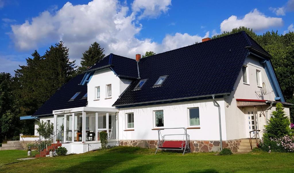 una casa blanca con techo negro en Villa Wiese, en Katzow