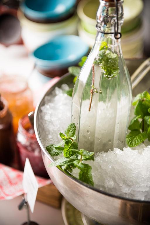a glass bottle filled with ice and green herbs at Hotel Daniel Vienna - Smart Lifestyle Near City Centre in Vienna