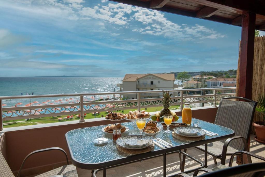a table on a balcony with a view of the ocean at Boho Sea View Studio in Planos