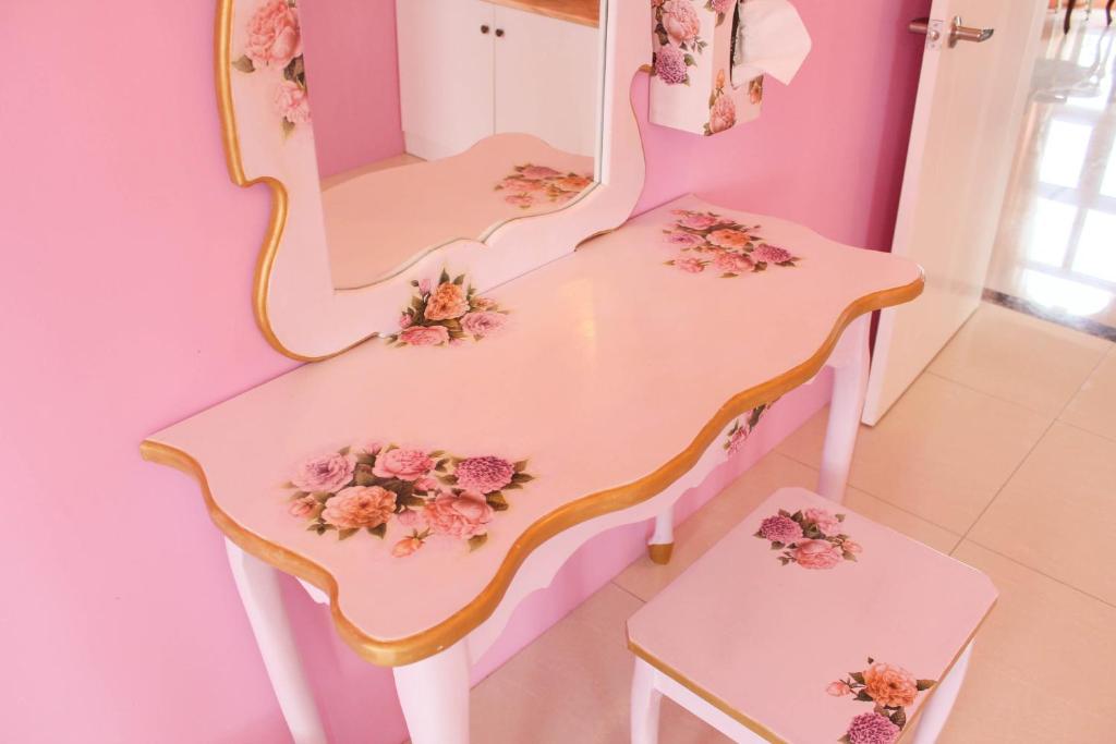 a dressing table with two chairs and a mirror at Decoupage Manor in Jiaoxi