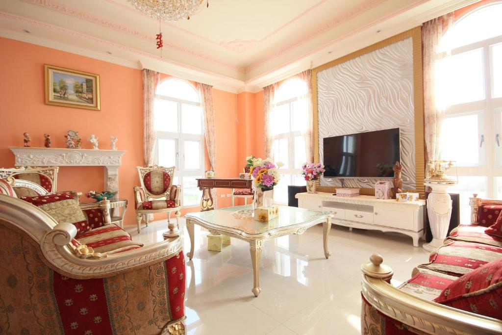 a large living room with orange walls and a tv at Decoupage Manor in Jiaoxi