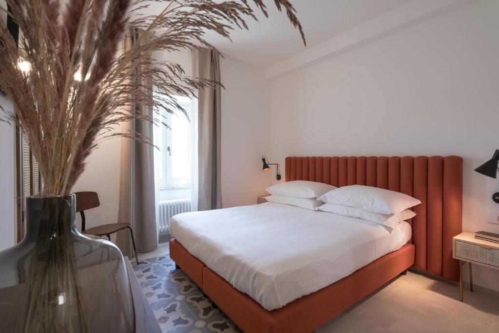 1 dormitorio con 1 cama y un jarrón con una planta en Heraia, en Ragusa