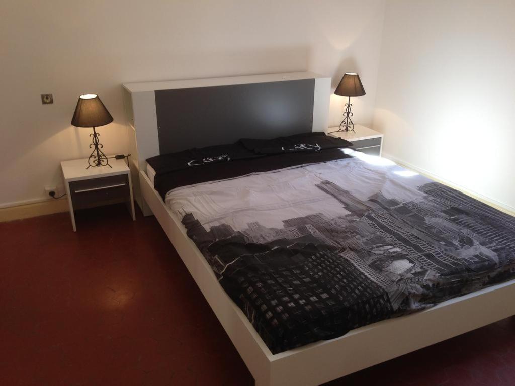een slaapkamer met een groot bed met 2 nachtkastjes bij Kalliste - Appartement centre ville tout équipé in Bastia