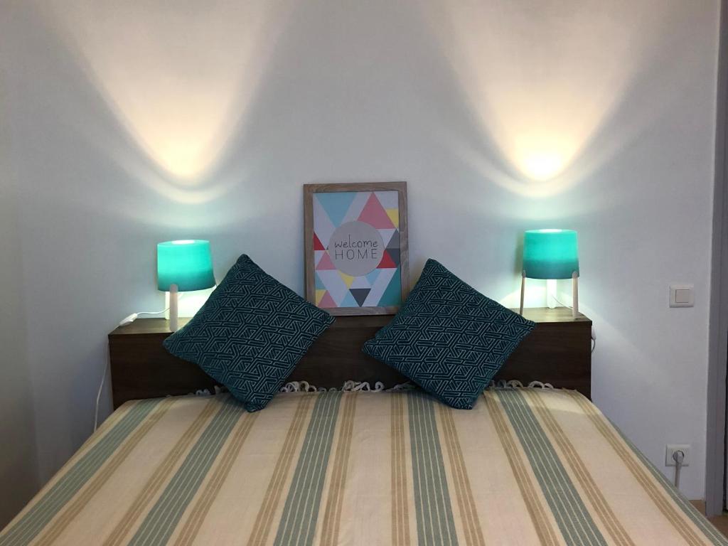 a bedroom with a bed with two blue lamps at Casella - Appartement centre ville tout équipé in Bastia
