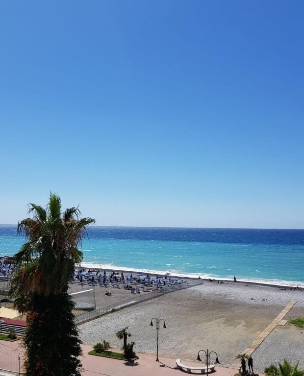 a beach with a lot of people and the ocean at Casalmare Sabina in Ventimiglia