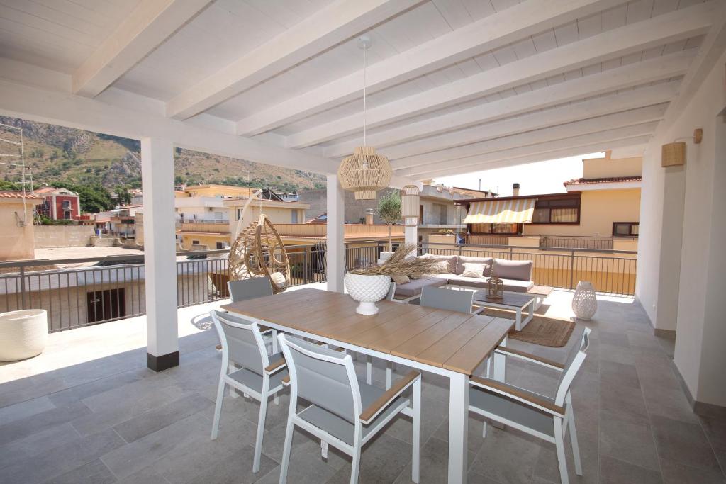 une terrasse avec une table et des chaises en bois. dans l'établissement Al Covo dei Mori, à Bagheria