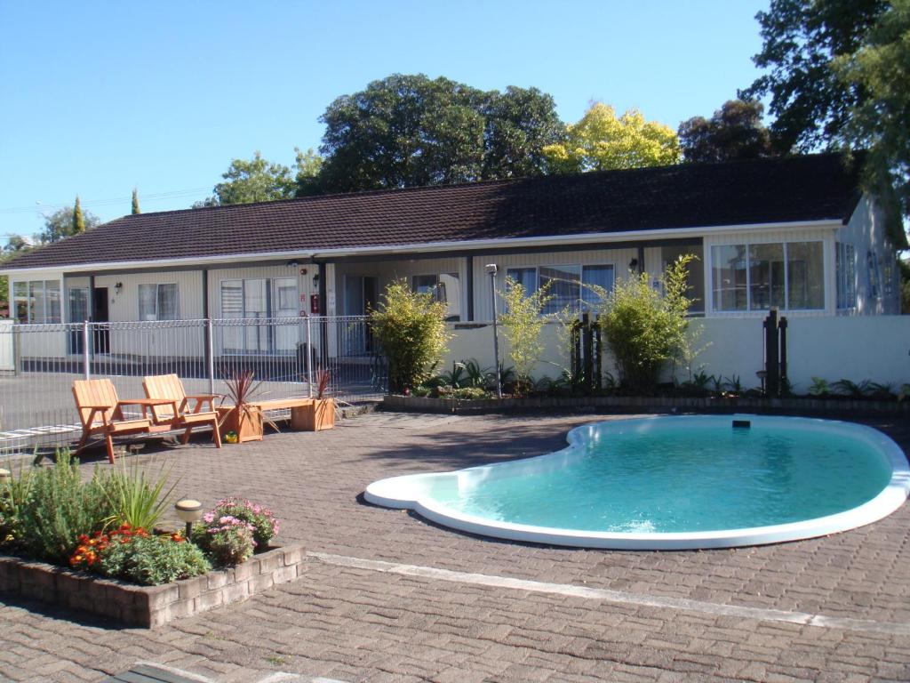 a swimming pool in the yard of a house at Acorn Estate Motel in Masterton