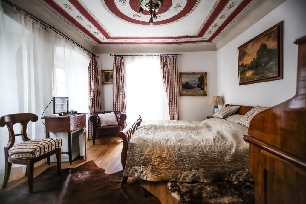 um quarto com uma cama, uma secretária e uma janela em Pension Cortes em Cesky Krumlov