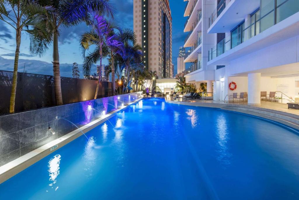 a large blue swimming pool in a building with palm trees at Wyndham Resort Surfers Paradise in Gold Coast