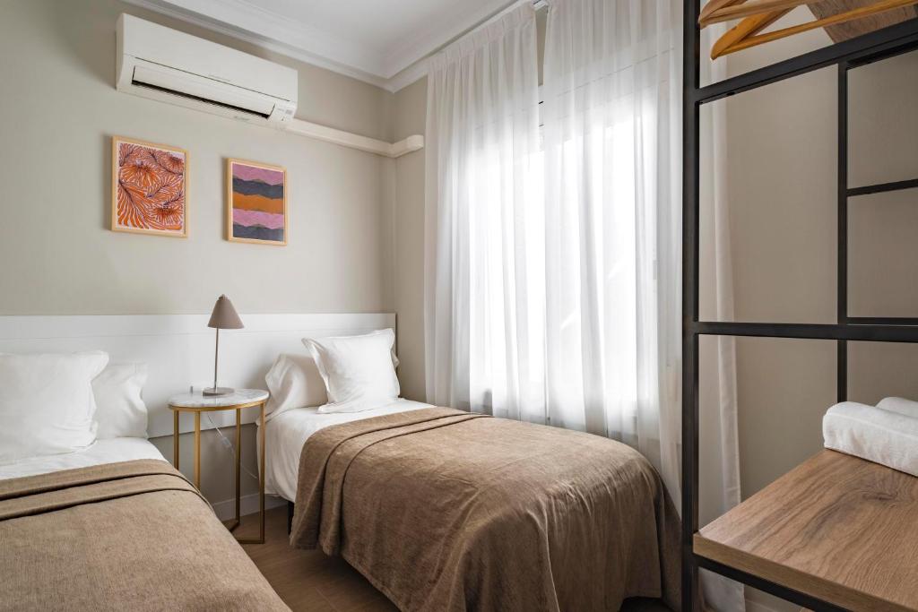 Posteľ alebo postele v izbe v ubytovaní Aspasios Rambla Catalunya Apartments