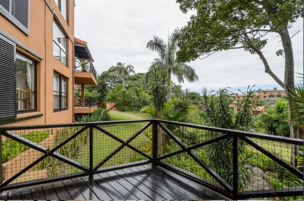 a balcony of a house with a wooden deck at San Lameer Villa 1928 by Top Destinations Rentals in Southbroom