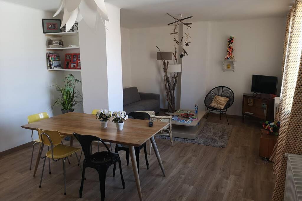 sala de estar con mesa de madera y sillas en Osanjes Berck plage, en Berck-sur-Mer