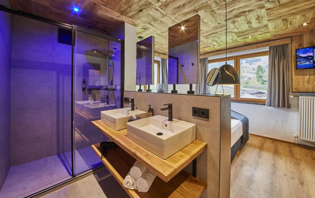 a bathroom with two sinks and a large shower at Chalet Wallehen in Saalbach Hinterglemm