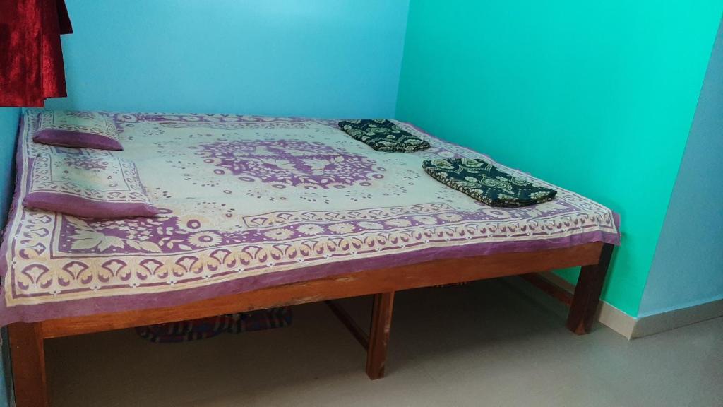 a small bed in a corner of a room at Sagar sandhya home stay in Dapoli