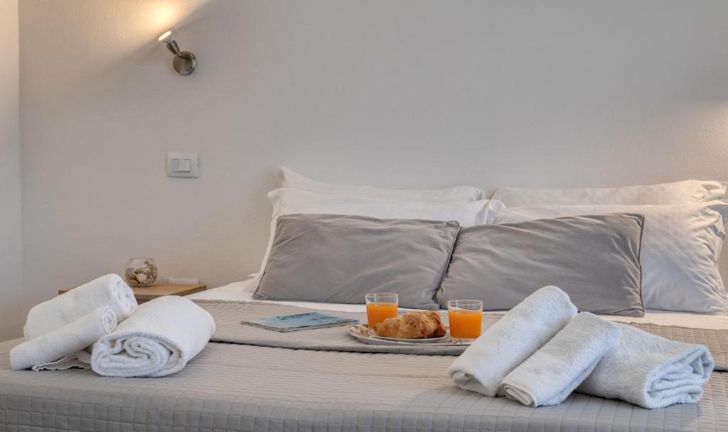 łóżko z tacą ręczników i 2 kieliszkami soku pomarańczowego w obiekcie IzzHome Cozy Sunflowers w Puli