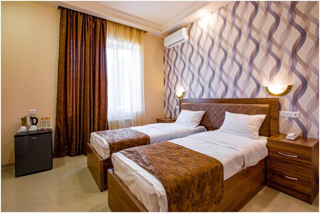 a hotel room with two beds and a window at Arma Boutique Hotel in Yerevan