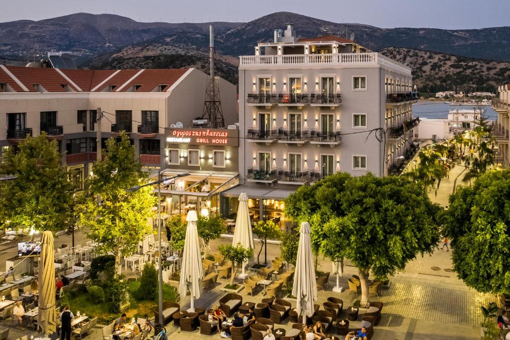 an image of a hotel with tables and umbrellas at Aenos Hotel in Argostoli