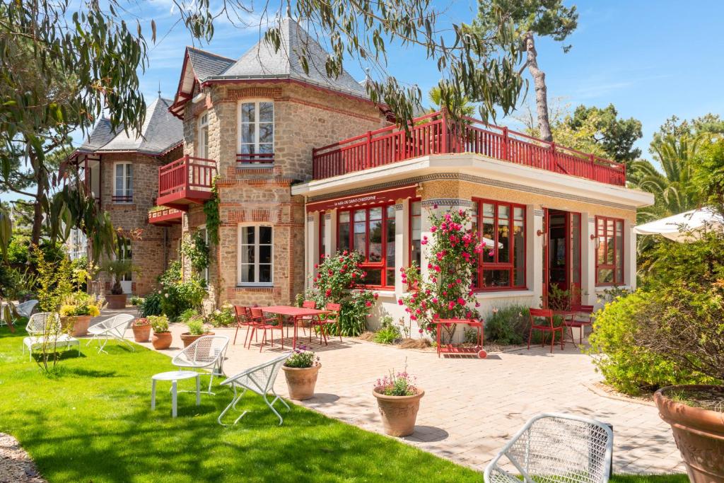 a house with a patio with tables and chairs at Hôtel Le Saint Christophe in La Baule