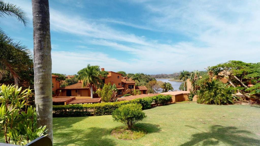 Blick auf ein Haus mit einem Hof mit einer Palme in der Unterkunft San Lameer Villa 2008 by Top Destinations Rentals in Southbroom