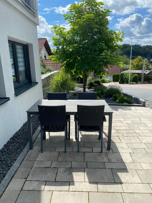 stół i krzesła na patio z drzewem w obiekcie Ferienwohnung Bachmann w mieście Leidersbach