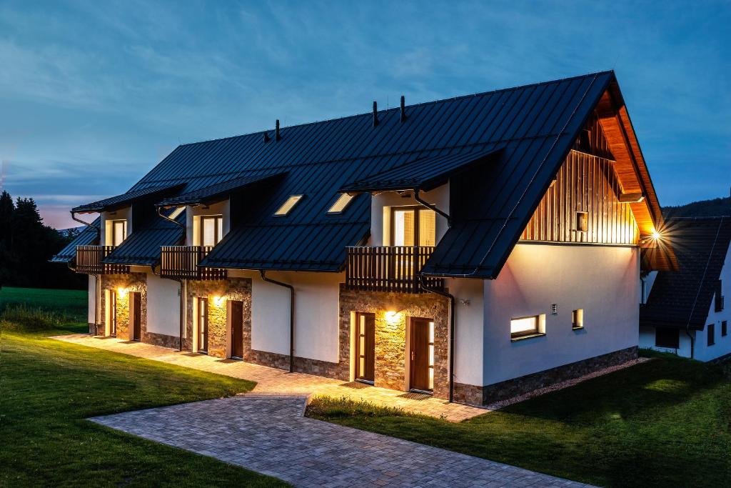 una casa con techo de metal negro en "PENZION NA BUKOVÉ HOŘE" - apartmánový dům, Horský resort Buková hora en Červená Voda